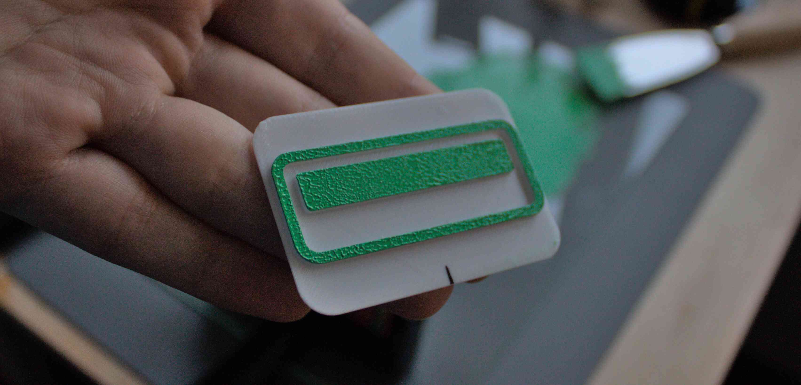 A white stamp with green ink applied. The ink has a distinct texture