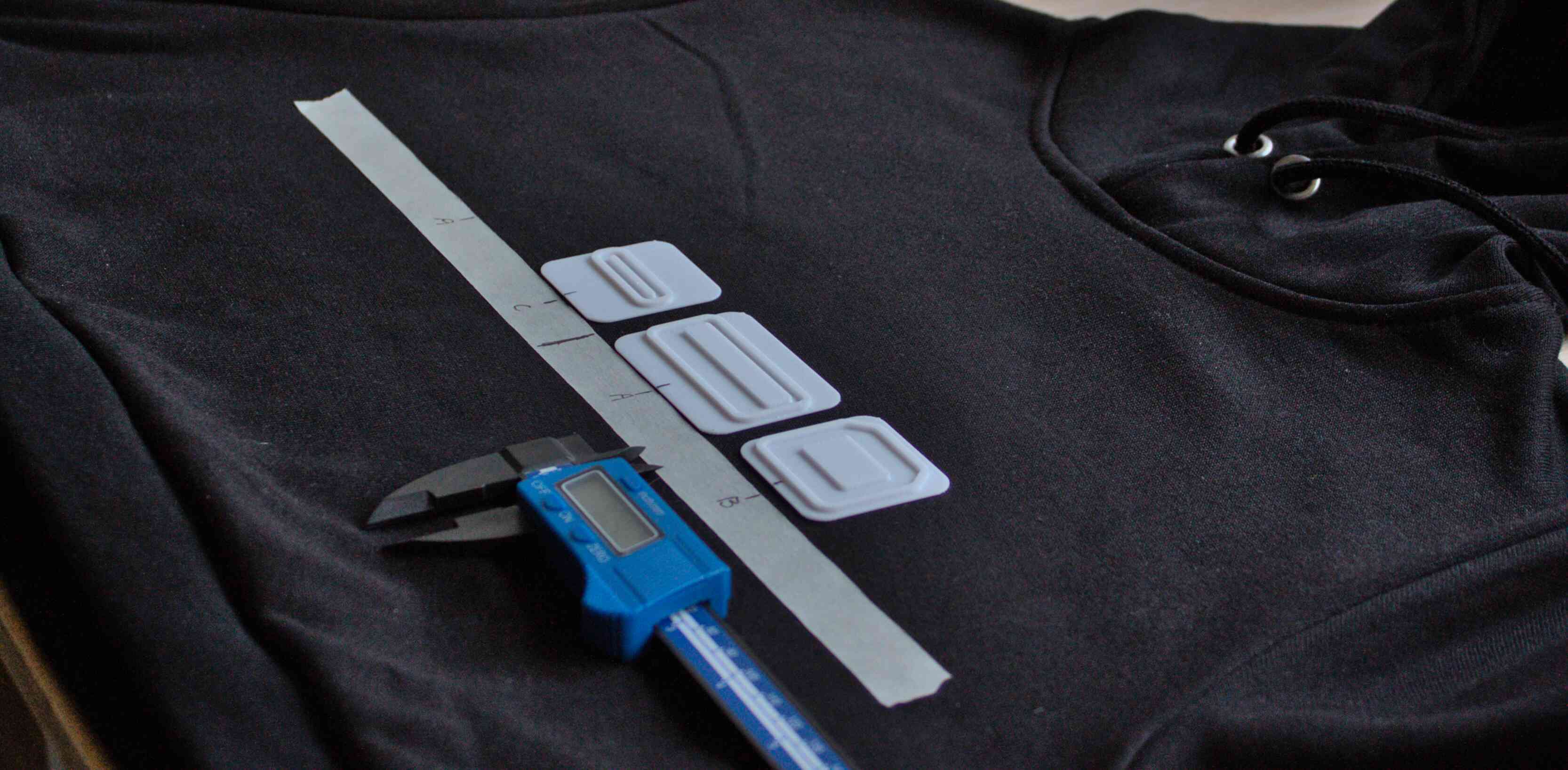 The hoodie with masking tape on the front, three stamps are lined up with registration marks