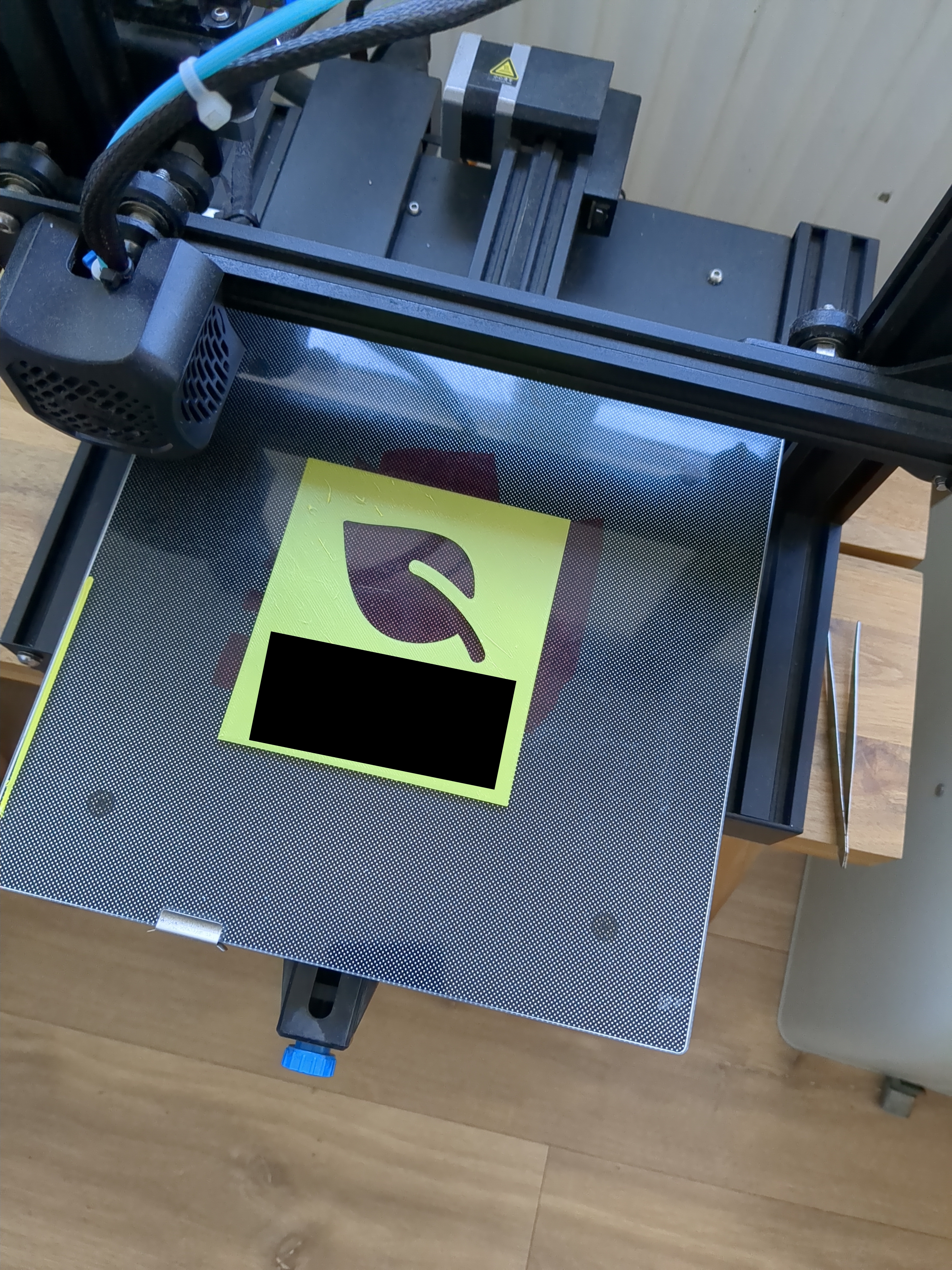 A yellow stencil with a leaf cutout. Part is censored