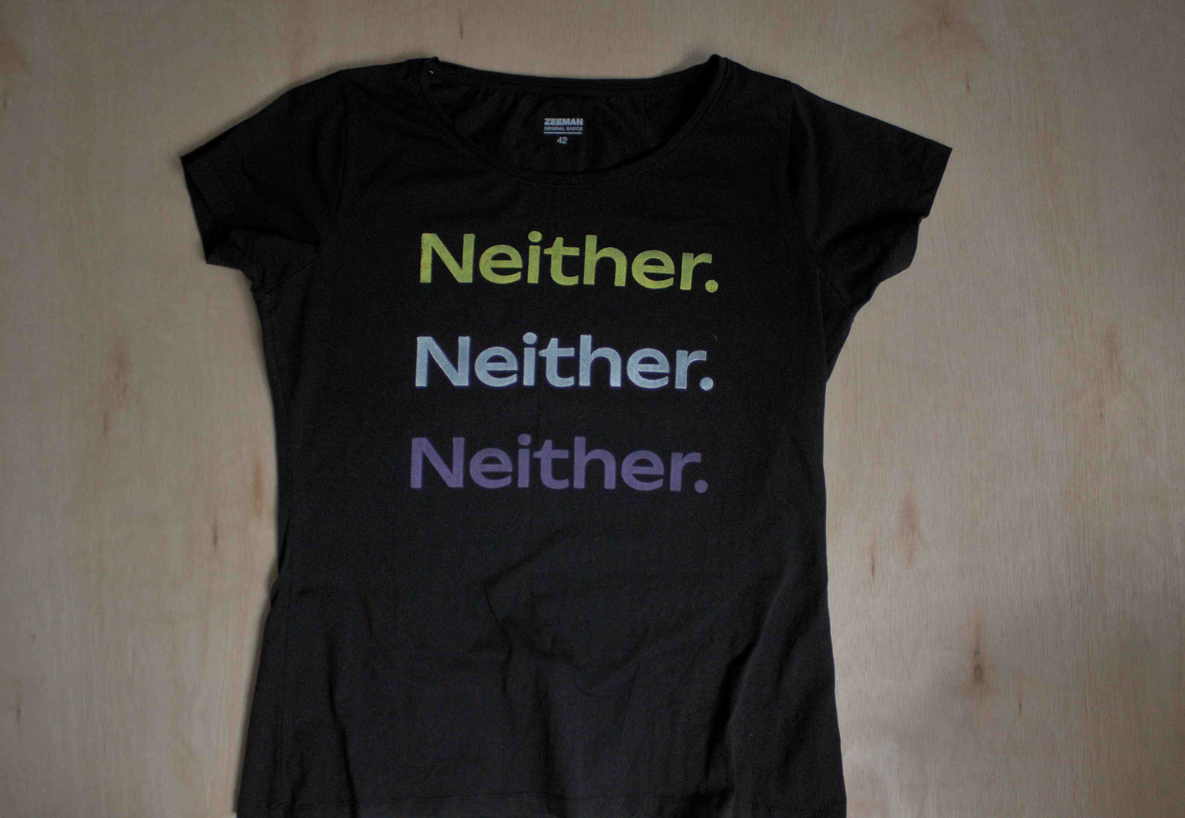 Black shirt with "neither." printed in yellow, white and purple