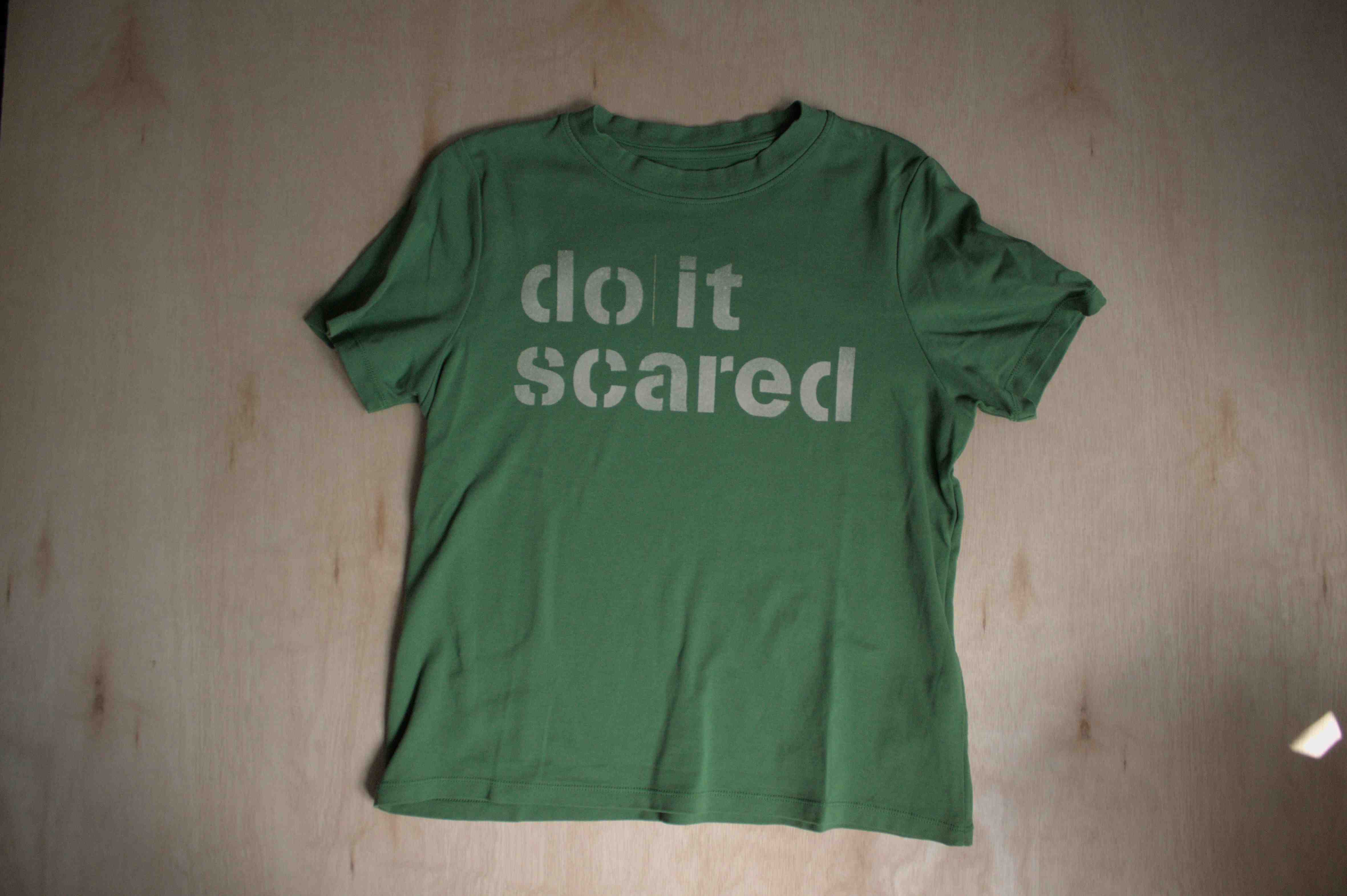 green shirt that says "do it scared"